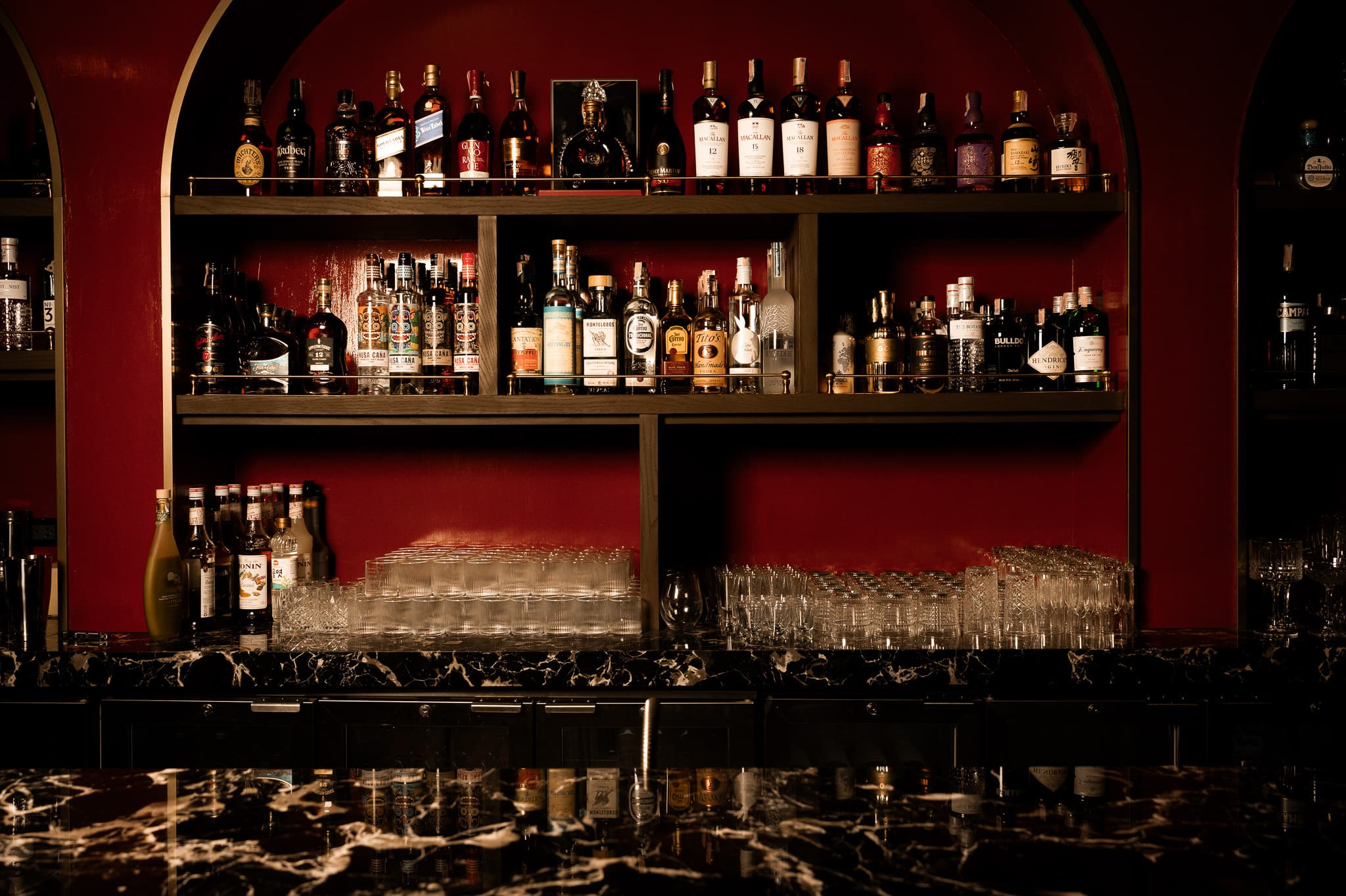 Moonshine bar interior showing red velvet decor, candlelit atmosphere, and elegant seating